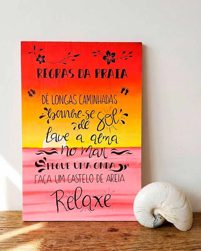 Letrero de madera "Regras da Praia" con degradado naranja y amarillo sobre estante.