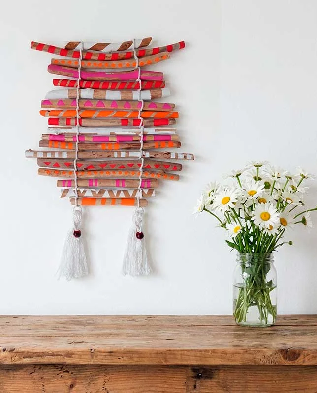 Palos de madera varada dispuestos a modo de estera y pintados a mano.