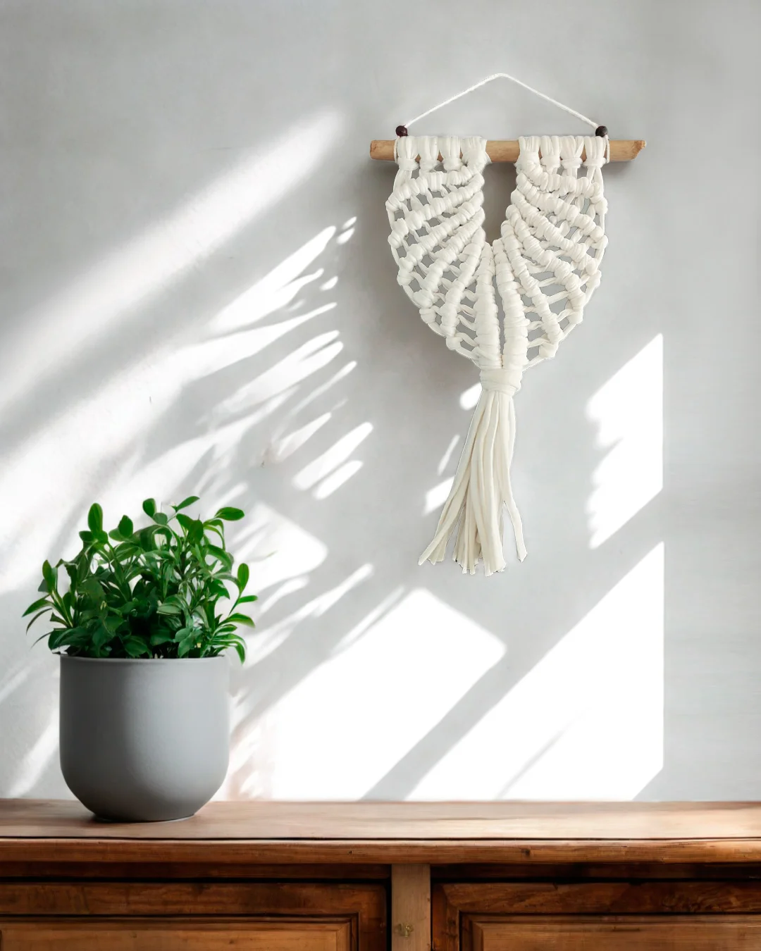 mini-macrame-forma-concha-blanca Macramé decorativo blanco con forma de concha marina y fleco central.
