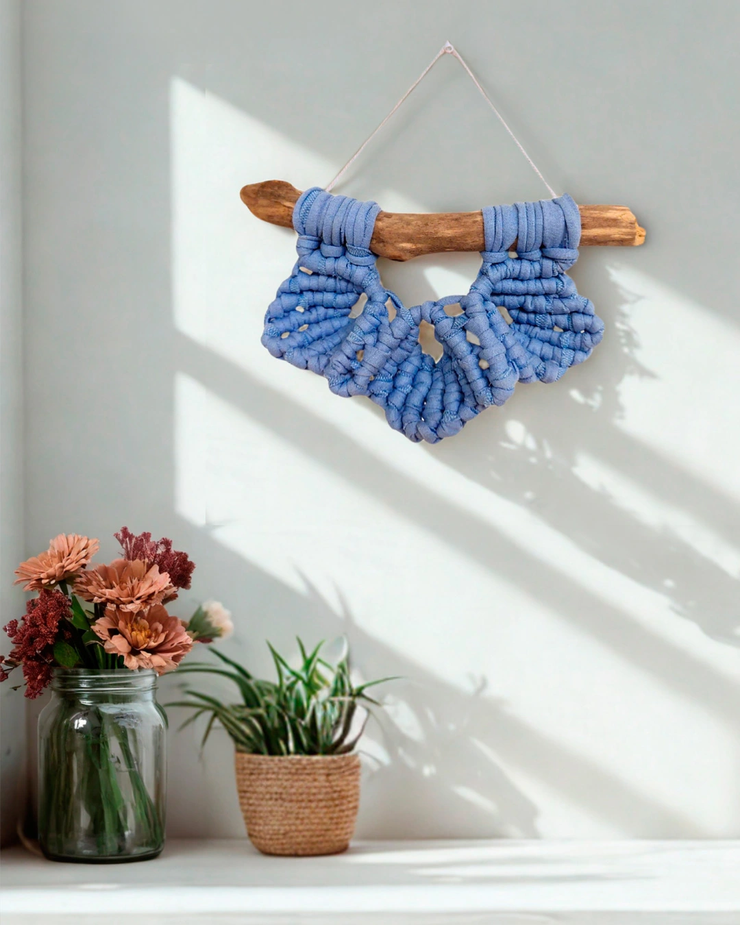 Mini macramé de tres hojas en algodón azul denim sobre madera varada.