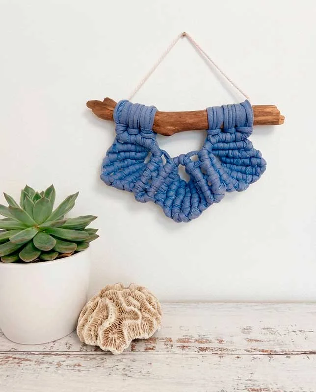 Mini macramé de tres hojas en algodón azul denim sobre madera varada.