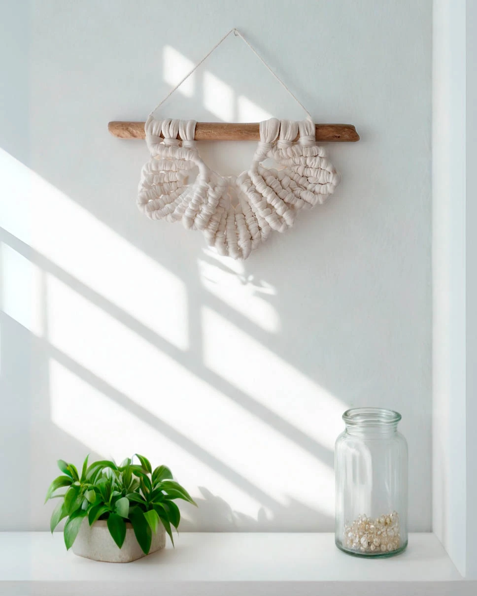 mini-macrame-tres-hojas-blancas Mini macramé de tres hojas en algodón blanco sobre madera varada clara.