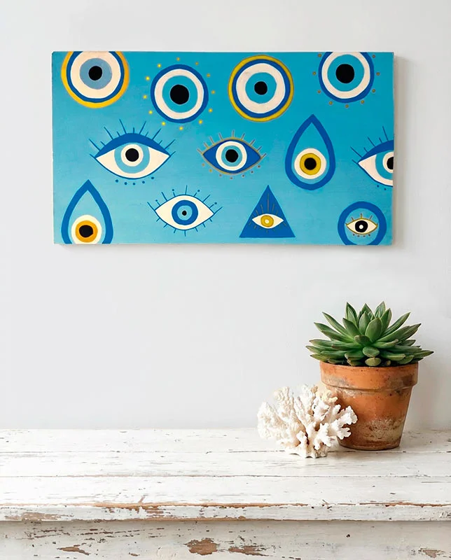 Letrero azul con varios ojos pintados a mano estilo amuleto protector.